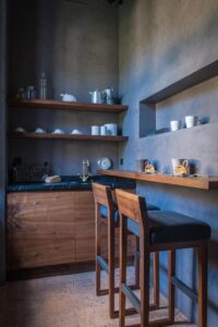 Dettaglio angolo cucina con mobili in legno e muro in pietra